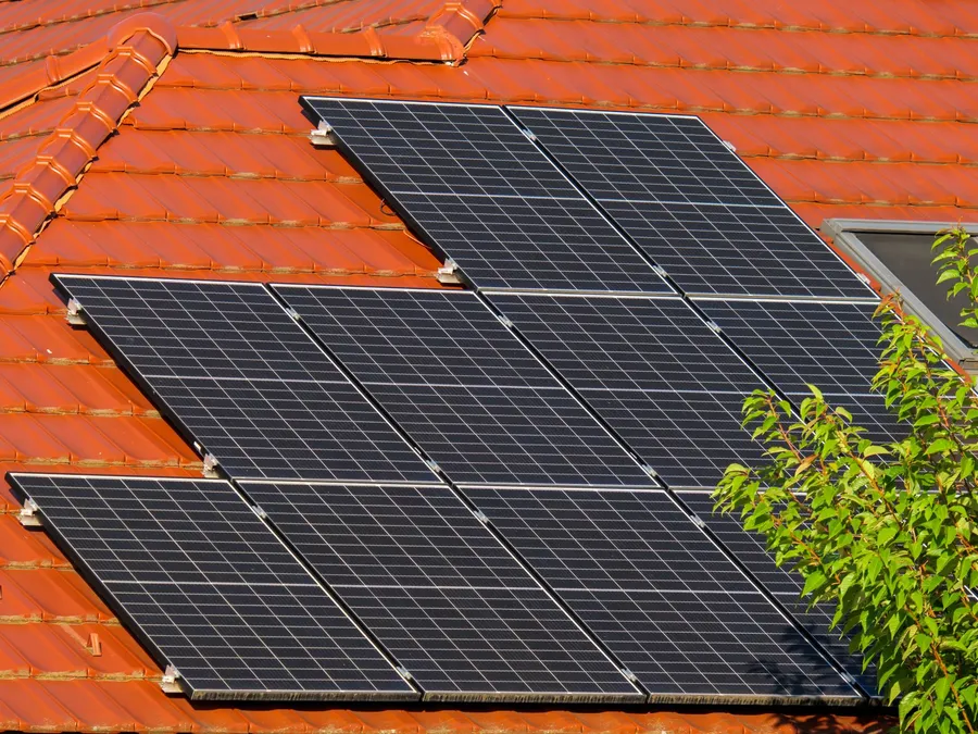 Solar panels mounted on a tiled residential roof, illustrative photograph