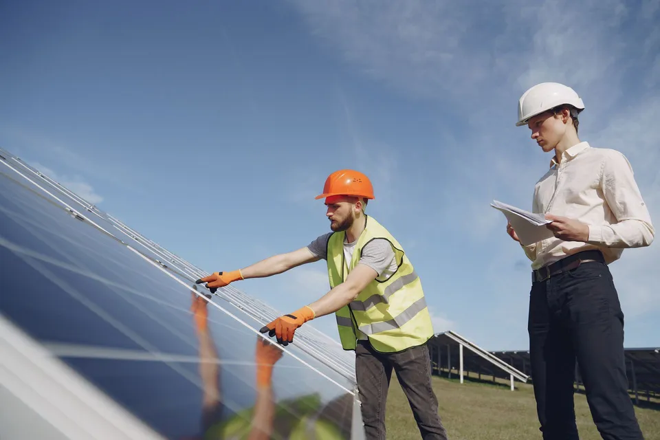 Solar technician explaining equipment to a customer, illustrative photograph
