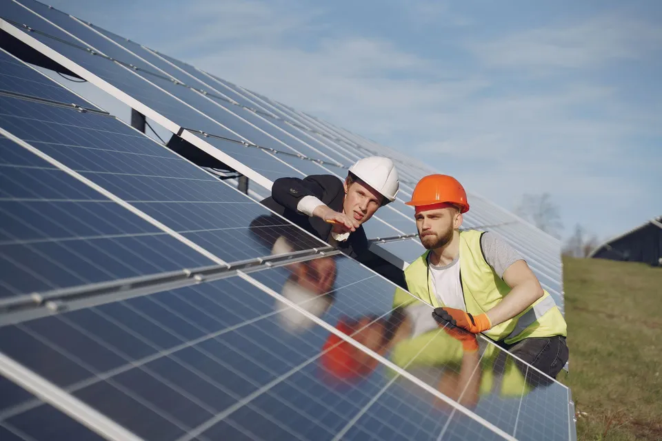 Solar technicians discussing a solar installation, illustrative photograph