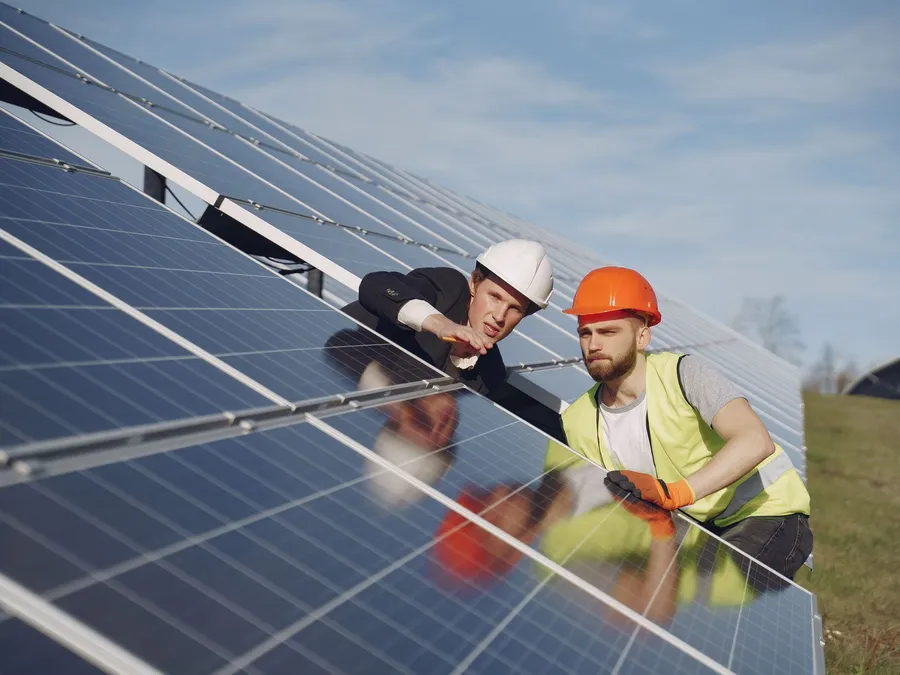 Solar technicians discussing a project, illustrative photograph